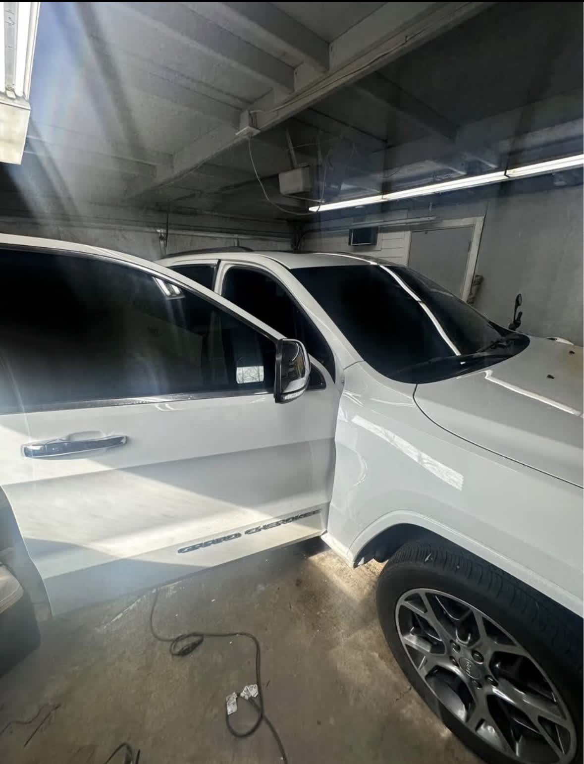 White Jeep inside an installation space with dark window tint